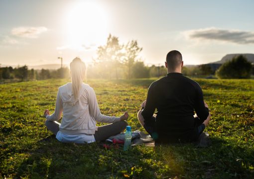 Dos personas haciendo Mindfullness en un parque