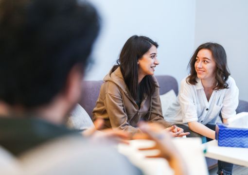 Dos mujeres hablando contentas en una consulta