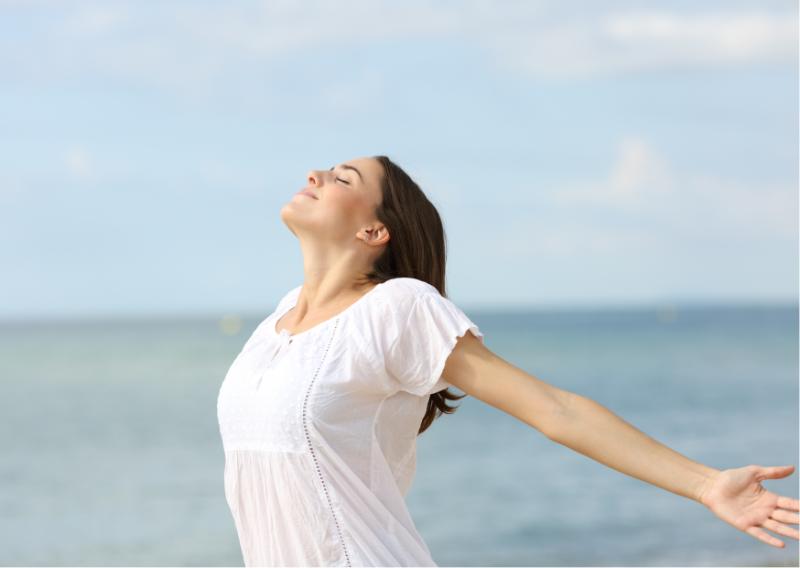 Mujer sintiendo el aire en una playa